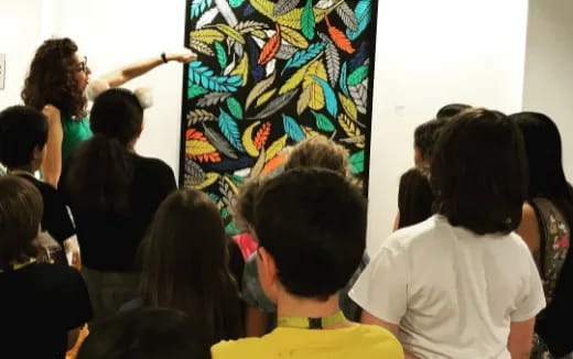 a group of people looking at a painting on a wall