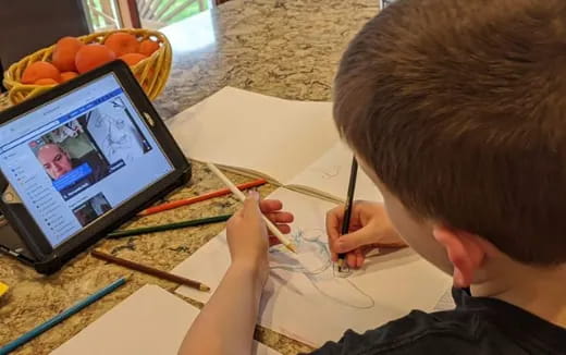 a child drawing on a tablet