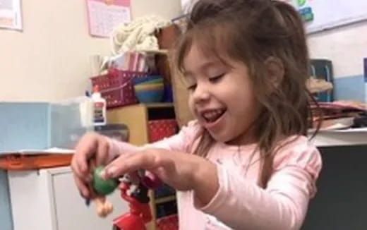 a girl holding a toy