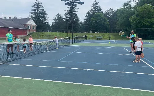a group of people playing tennis