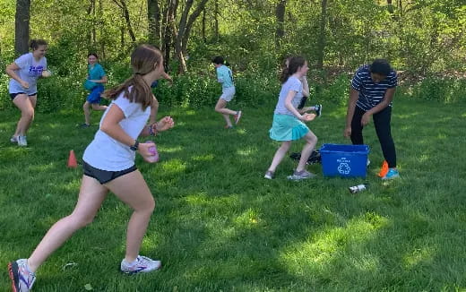 a group of people running on a grass field
