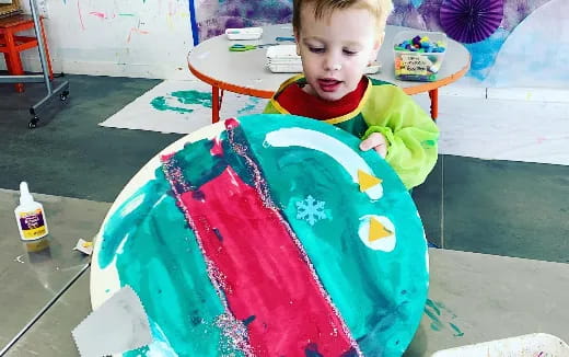 a child sitting at a table with a cake