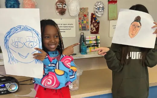 a girl holding a drawing