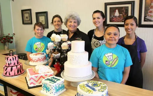 a group of people posing for a photo with cakes