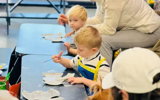 a group of children sitting at a table eating food