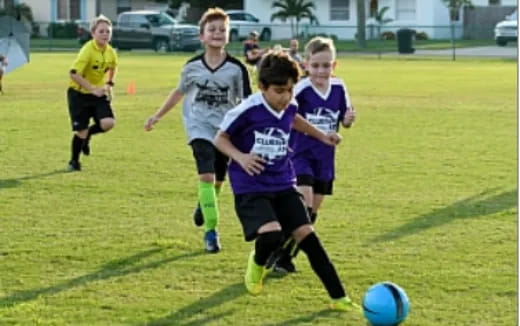 kids chasing a football ball