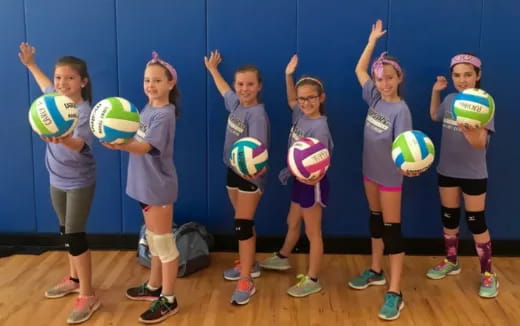a group of girls holding balls