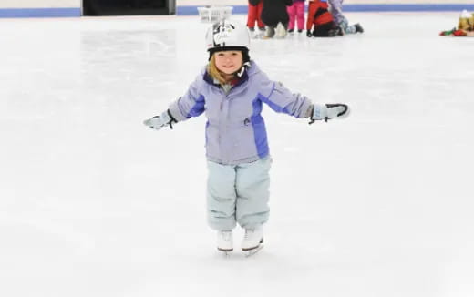 a girl wearing a helmet and ice skates