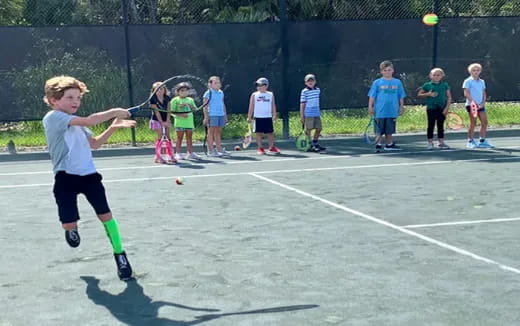 a kid playing tennis