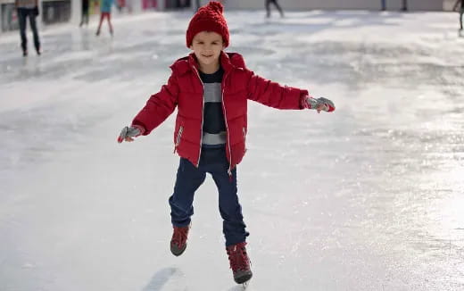 a child wearing a red hat and standing in the snow