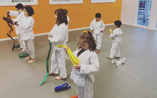 a group of children in white karate uniforms