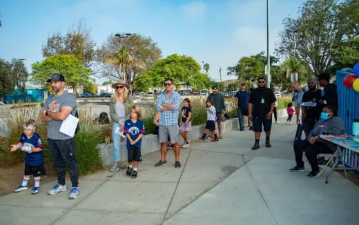 a group of people walking on a sidewalk