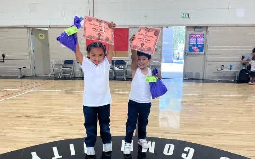 two kids holding bags of food