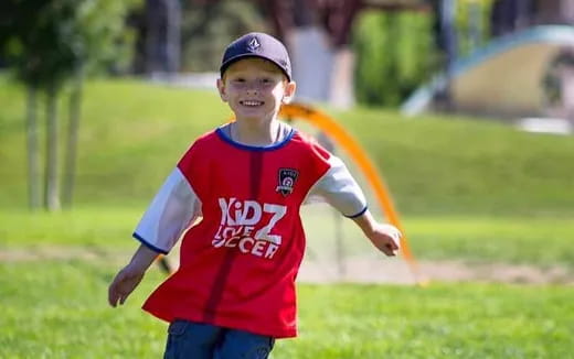 a boy running on a grass field