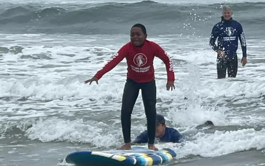 a group of people surfing in the sea