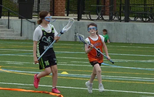 girls holding lacrosse sticks