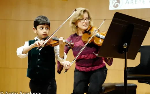 a boy and girl playing violin