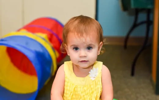 a baby in a yellow dress
