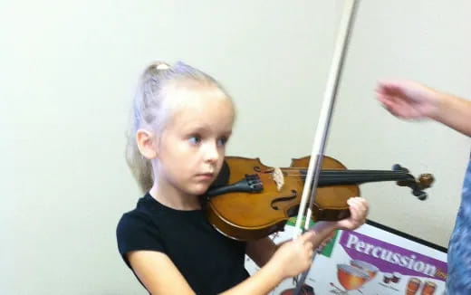 a young girl playing a violin