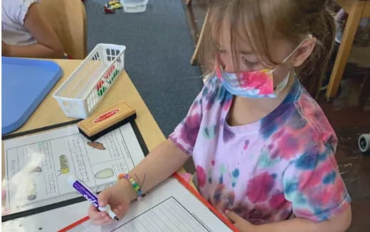 a young girl coloring on paper