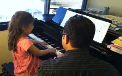 a man and a woman playing piano