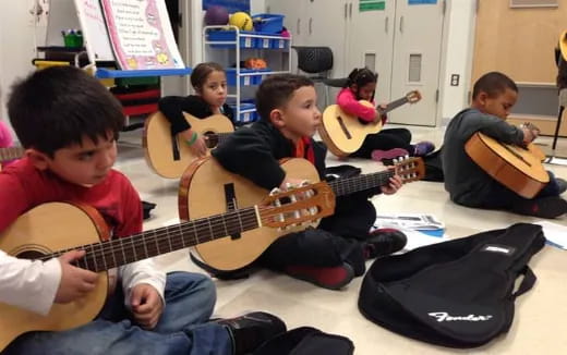 a group of kids playing guitars