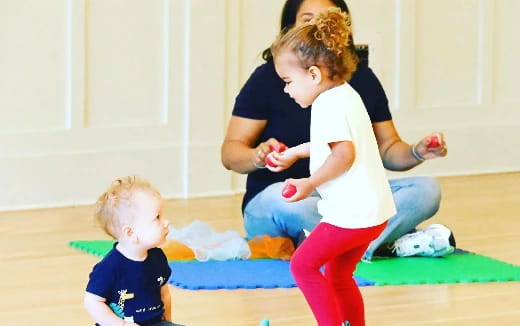 a person and a child playing with a ball on the floor