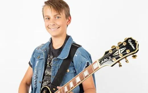 a boy holding a guitar