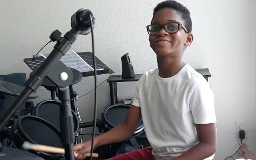 a man sitting in front of a drum set