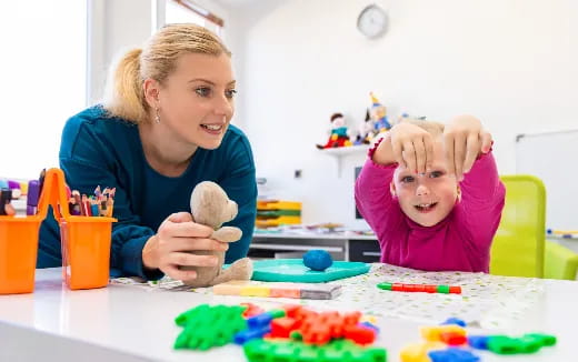 a person and a child playing with toys on a table