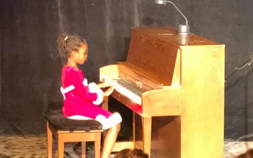 a girl playing a piano