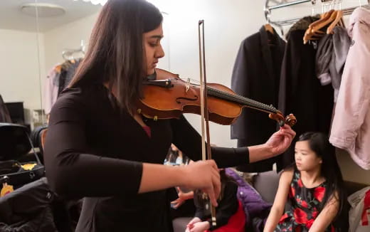 a woman playing a violin