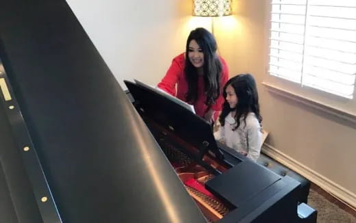 a woman and a girl sitting at a computer