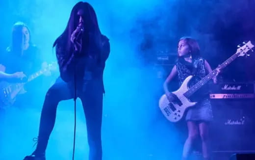 a couple of people playing guitars on a stage