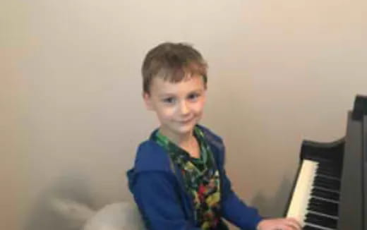 a boy playing a piano