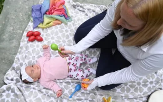 a woman playing with a baby