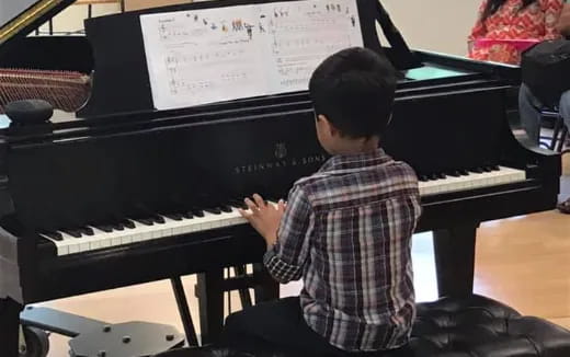 a boy playing a piano