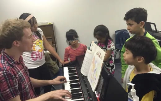 a group of children playing piano