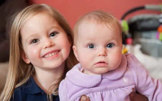 a girl holding a baby