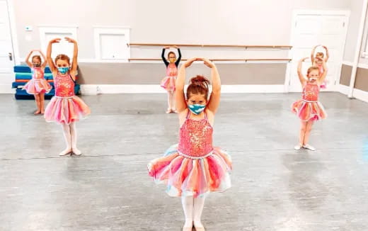 a group of girls in dresses dancing