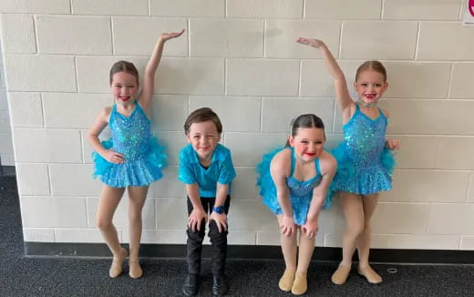 a group of children in blue dresses