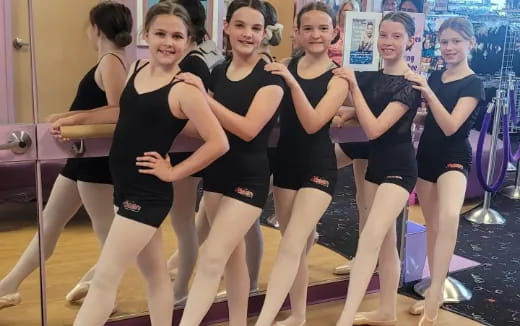 a group of women in leotards posing for a photo