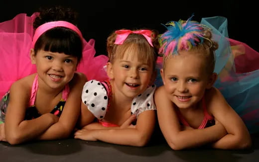 a group of children wearing pink dresses