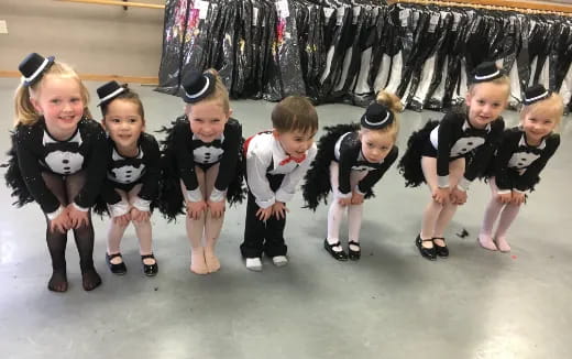 a group of children wearing black and white uniforms