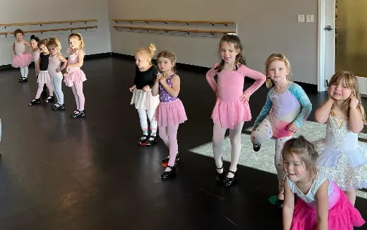 a group of girls in dresses dancing