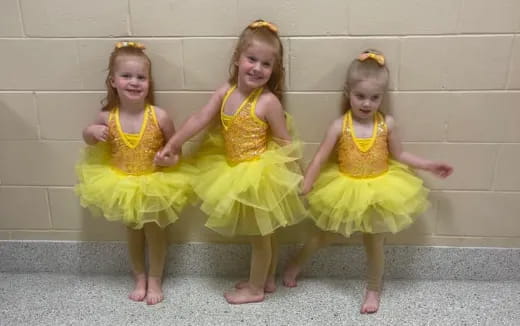 a group of girls wearing yellow dresses