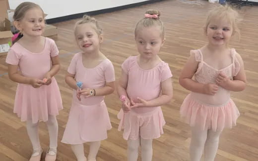a group of girls in pink dresses