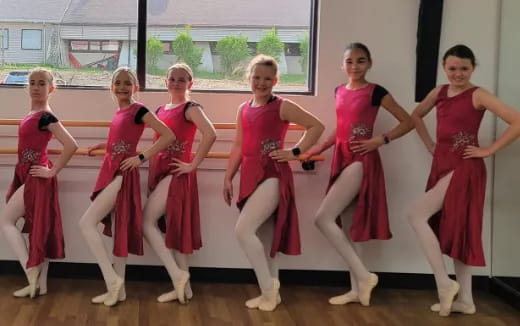 a group of women in red dresses