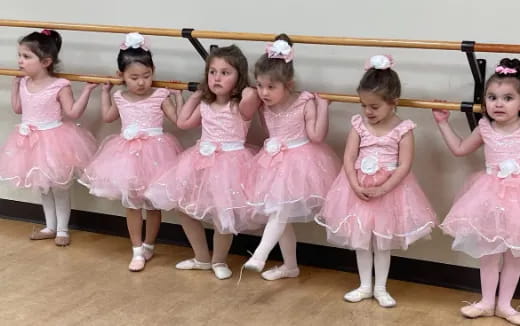 a group of girls in pink dresses