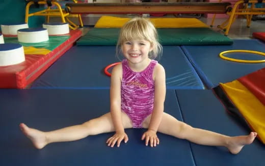 a girl sitting on a mat